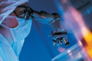 Scientist in laboratory studying bioactive components of deer velvet using advanced microscope, demonstrating precision and scientific rigor in researching regenerative properties