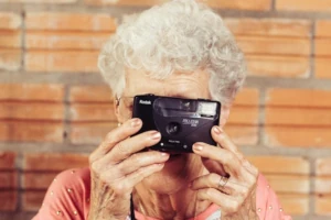 Active senior woman photographing the world around her, symbolizing the preservation of vitality and cognitive functions in older age that can be supported by natural compounds from deer velvet