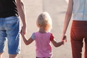 Child holding hands with parents, symbolizing healthy growth and development that can be naturally supported by bioactive compounds found in deer velvet